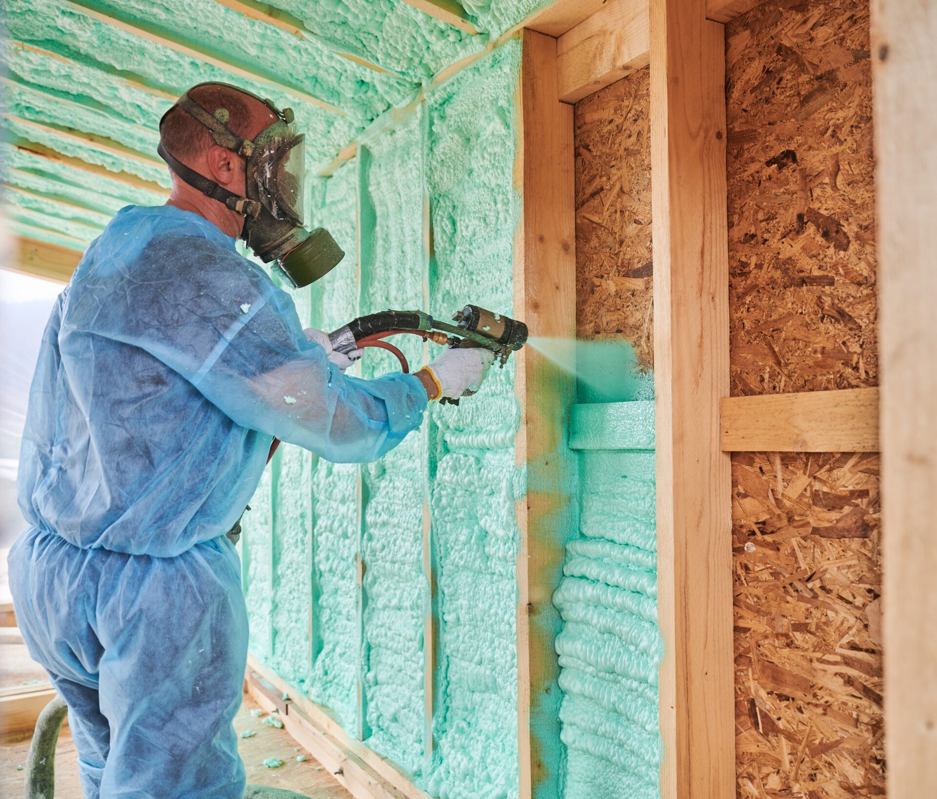 Technician applying spray foam insulation to a wall in a Surprise, AZ home